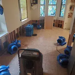 Two-story living room with flood cuts, air movers and dehumidifier running