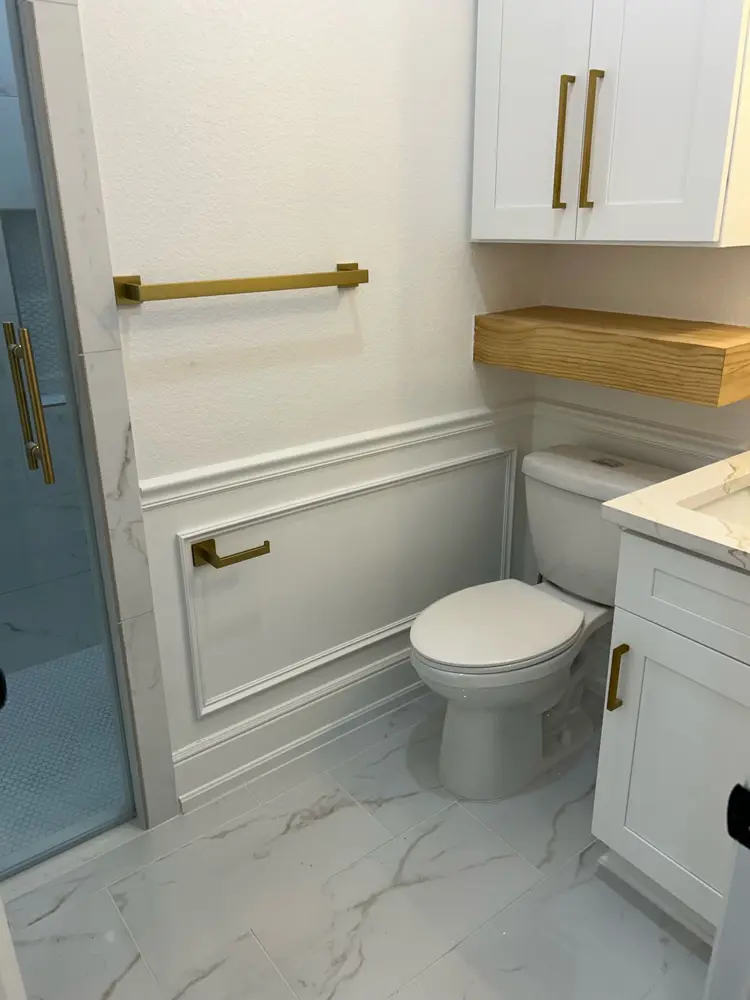 Finished bathroom with wainscoting and brass hardware