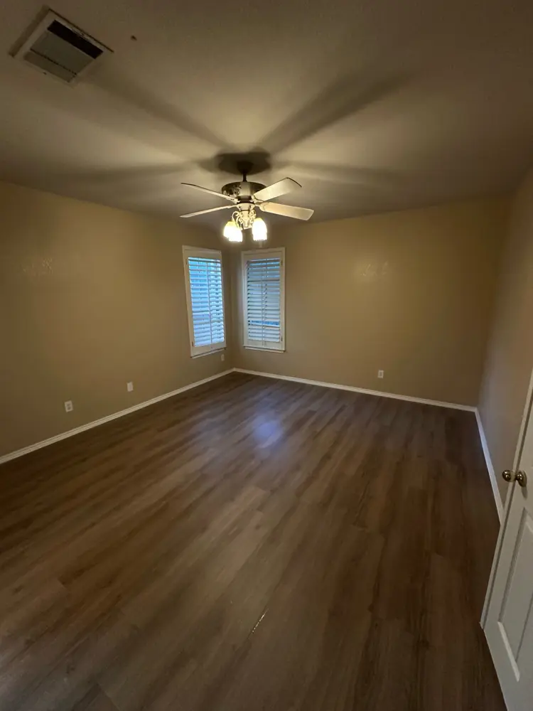 Finished bedroom with new LVP floor and ceiling fan