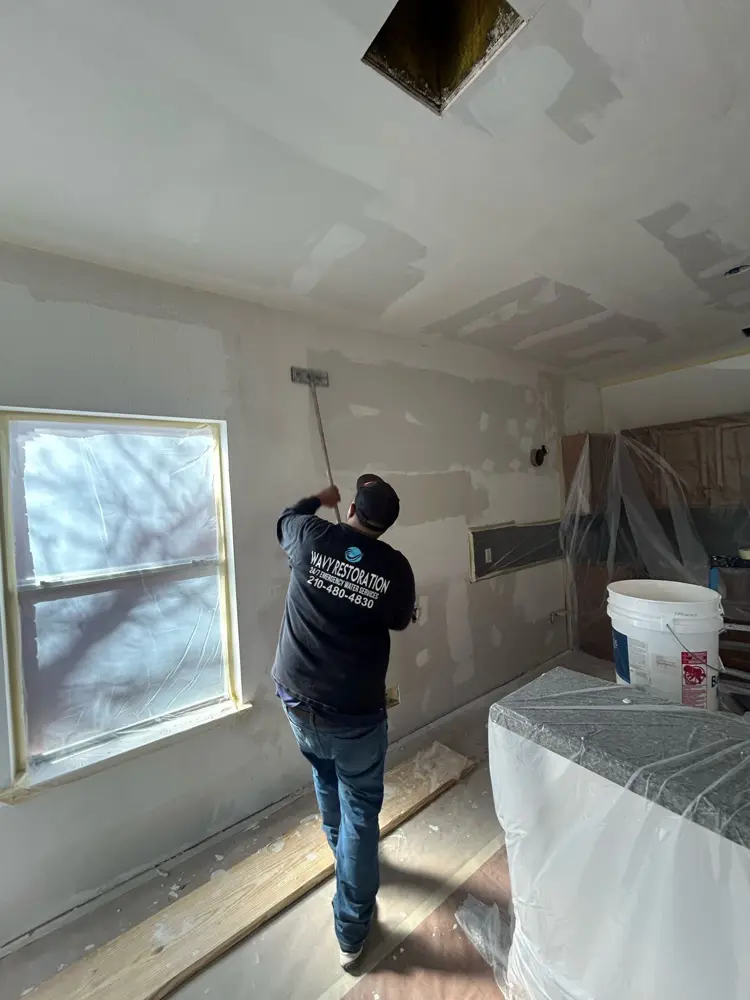 Crew prepping and skim-coating walls after demolition