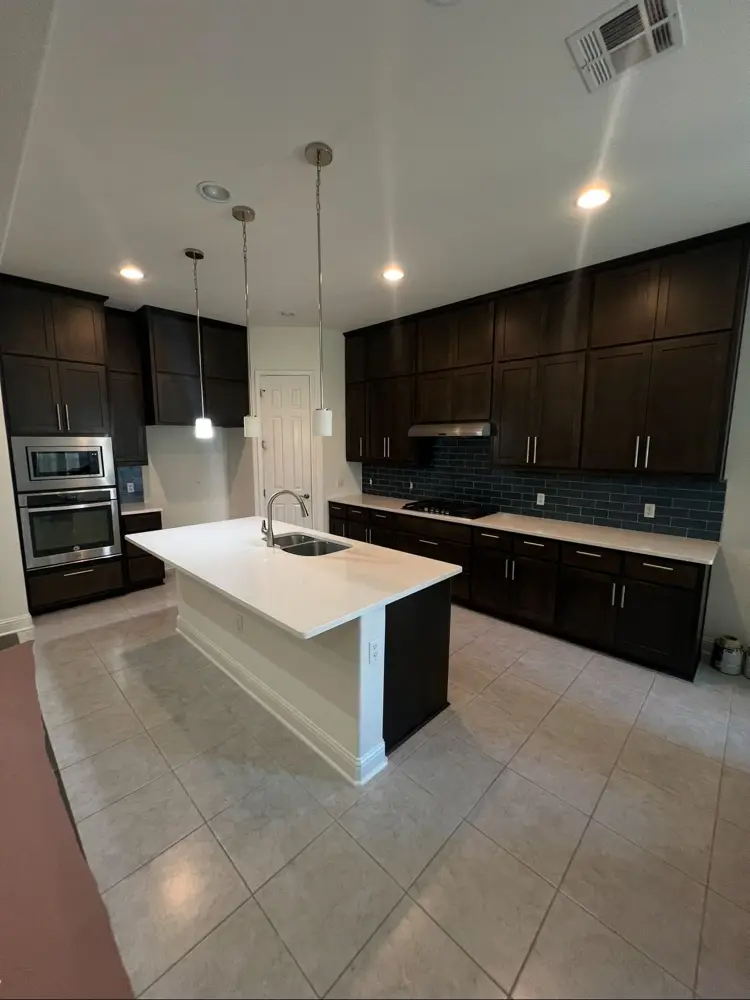 Finished kitchen with dark cabinets and white island counter