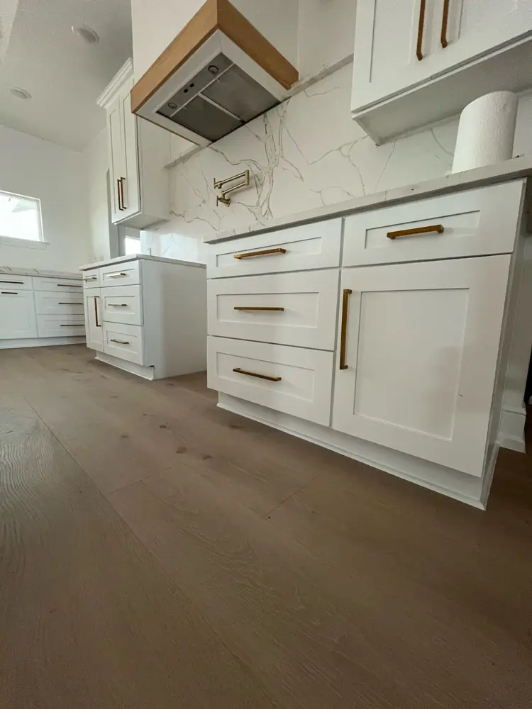 Finished white kitchen rebuild with island, range hood and brass pulls