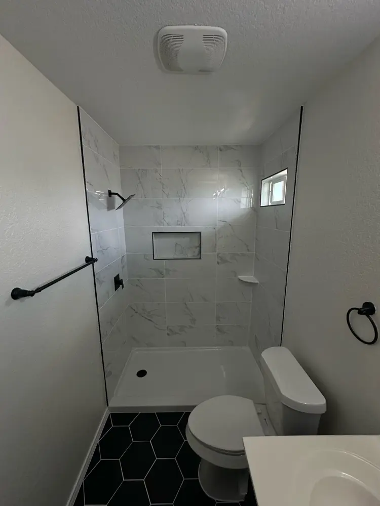 Finished shower with marble hex niche and black fixtures