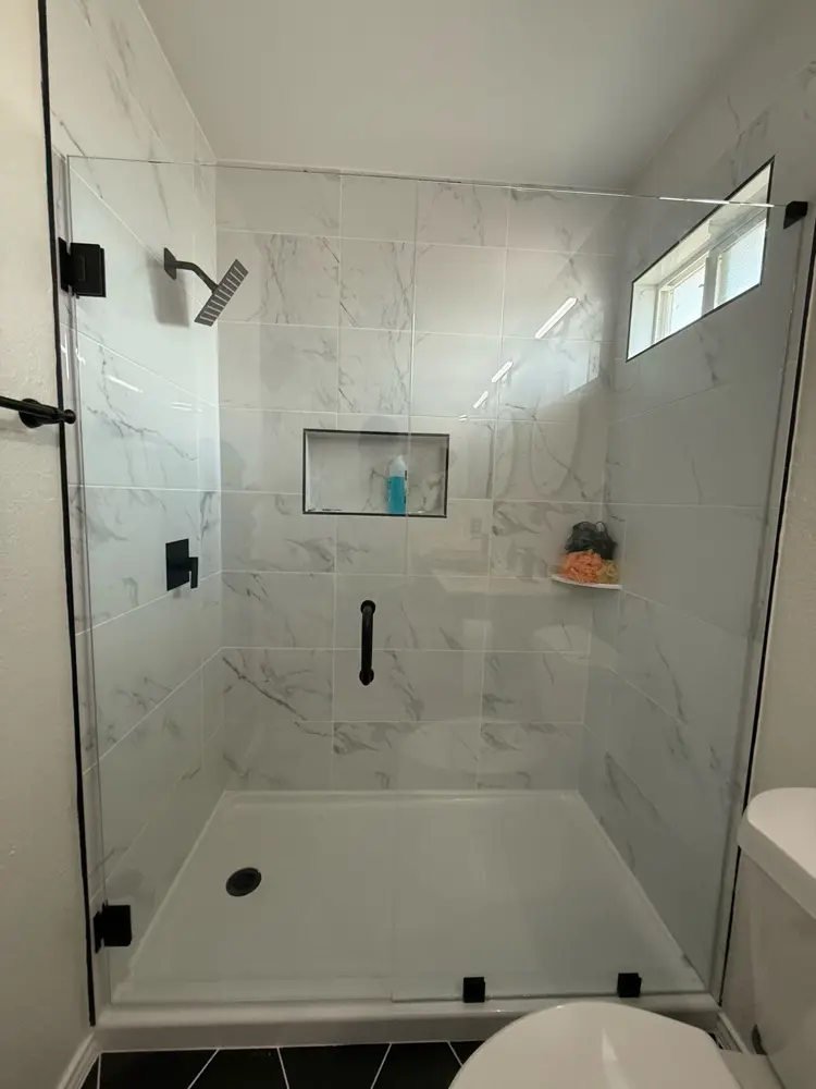 Finished marble-look shower with window and storage niche