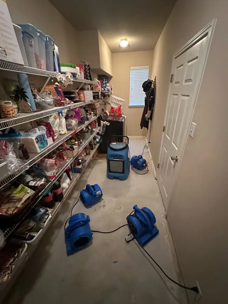 Air movers drying a storage closet after a leak