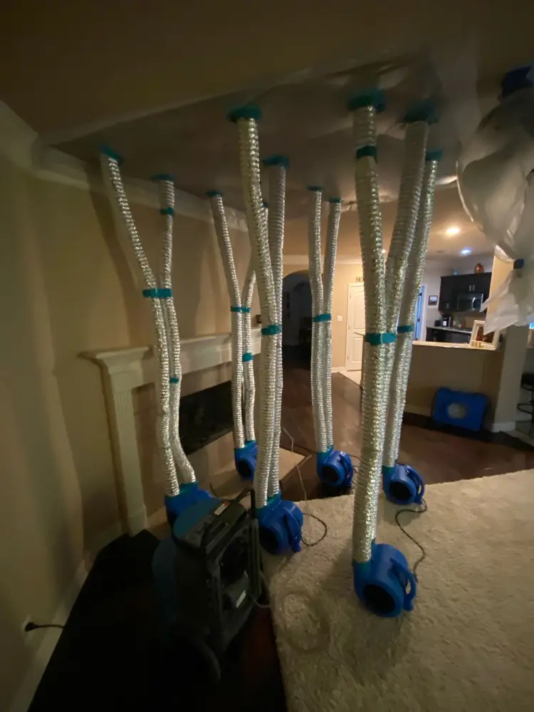 Ducted air movers drying a den ceiling after an upstairs leak