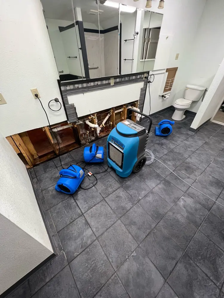 Dehumidifier and air movers drying a tiled living room