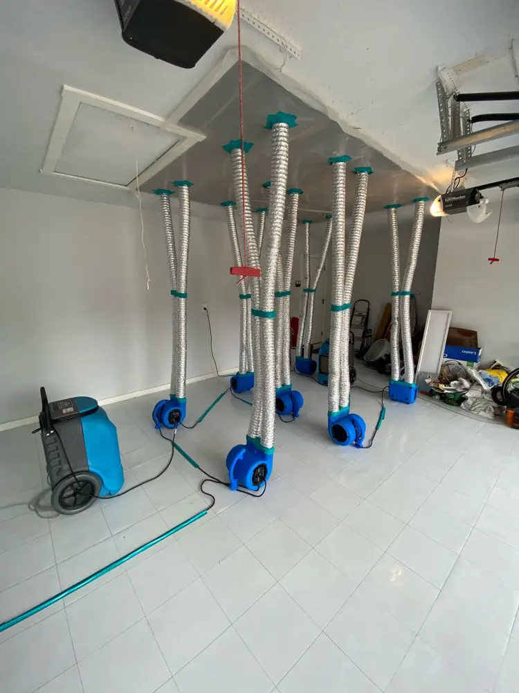 Ducted air movers drying a garage ceiling after a leak