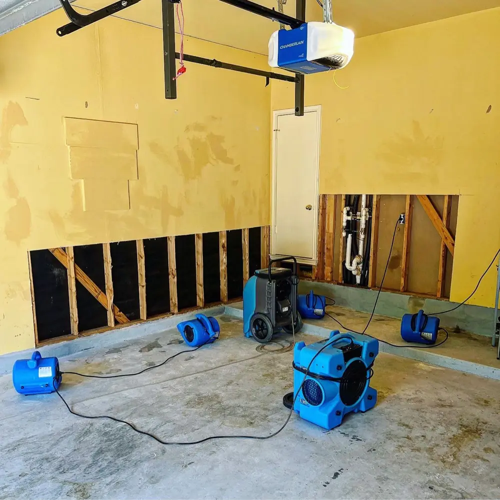 Garage walls flood-cut with air movers drying the studs