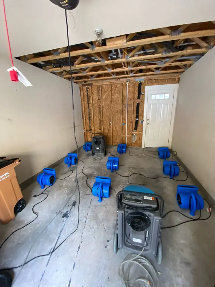 Garage stripped to studs with drying equipment running